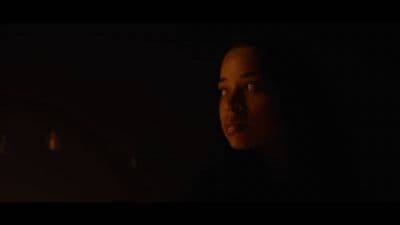 a woman in a dark room with a candle in her hand