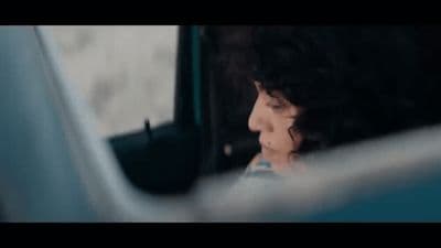 a woman sitting in a car looking out the window