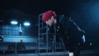 a young man with red hair and a black jacket