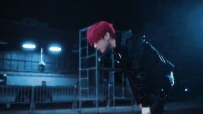 a young man with red hair and a black jacket