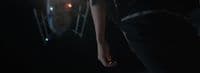 a person standing in the dark with their hand on their hip