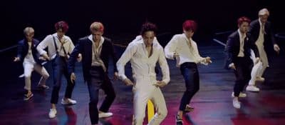 a group of men in suits and ties on a stage