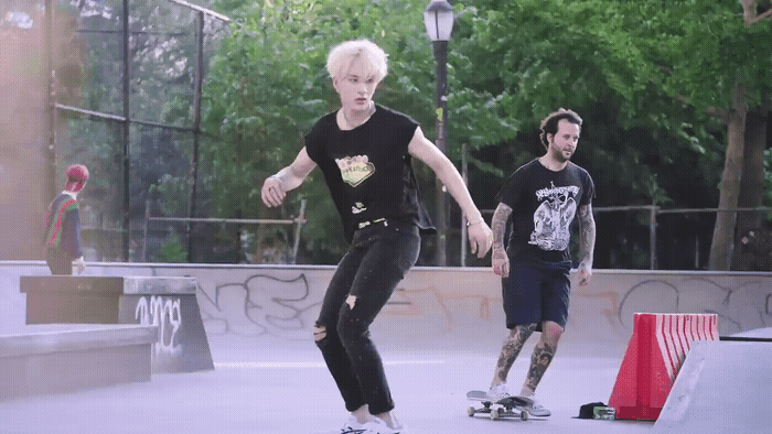a man riding a skateboard next to another man on a skateboard