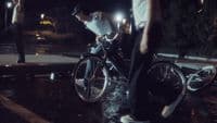 a man riding a bike down a street at night