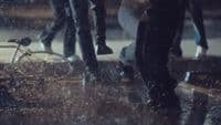 a couple of people walking down a street in the rain