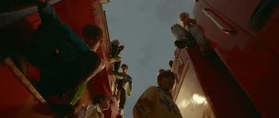 a group of people standing on the side of a bus