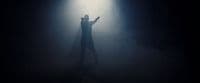 a person standing in the dark with their arms outstretched