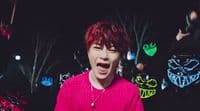 a person with red hair and a pink sweater