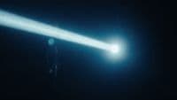 a person standing in the dark holding a flashlight