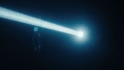 a person standing in the dark holding a flashlight
