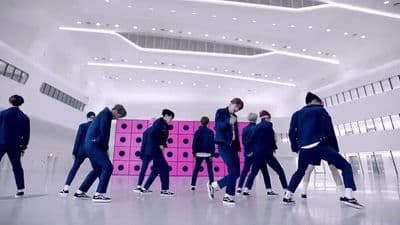 a group of men in suits and sneakers walking in a room