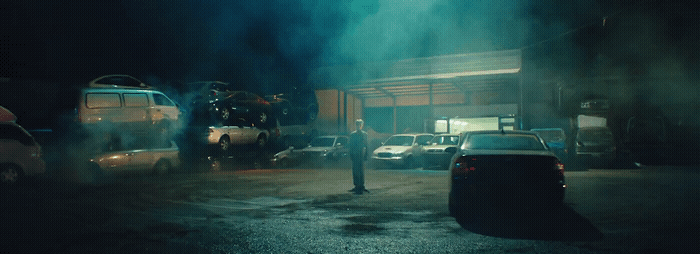 a man standing next to a car in a parking lot