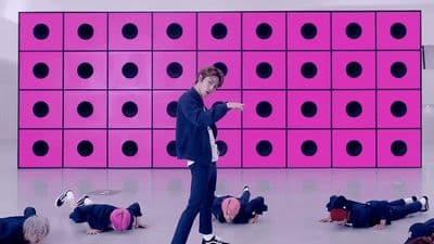 a man standing in front of a pink wall