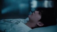 a man laying in bed with his eyes closed