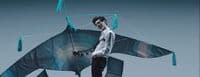 a man is holding a kite shaped like a shark