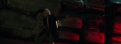 a man standing in front of a pile of cars