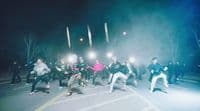 a group of people standing on a street at night