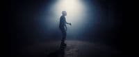 a man standing in a dark room with a light shining on him