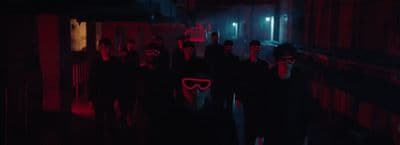 a group of people wearing masks in a dark hallway