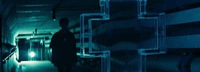 a man standing in a dark room next to pipes