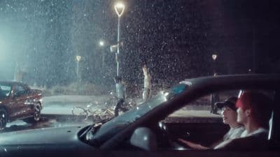 a woman driving a car in the rain at night