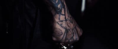 a man with a tattoo on his arm holding a cell phone
