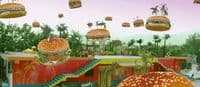 a large hamburger with many hamburgers flying above it