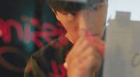 a young man looking at his reflection in a mirror