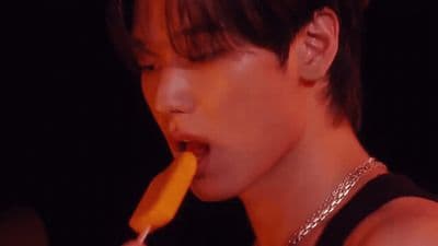 a young man eating a carrot with his tongue out