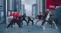 a group of young men dancing in a city