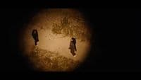 a couple of people walking down a dirt road