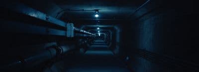 a long dark hallway with benches and lights
