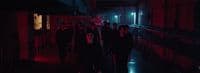 a group of people walking down a dark hallway