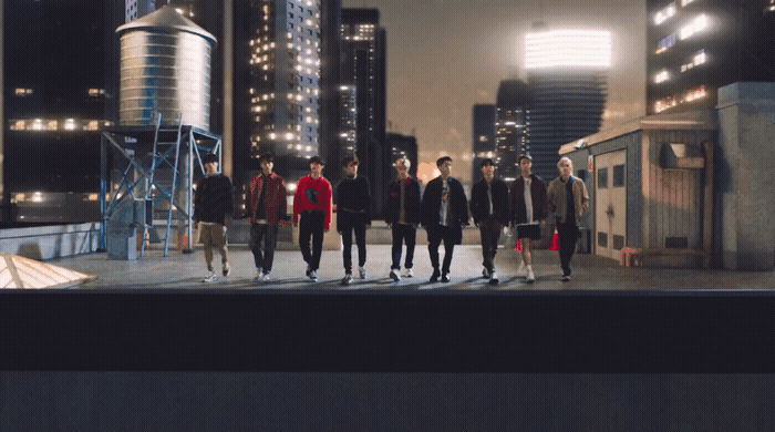 a group of young men walking across a city street