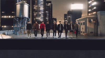 a group of young men walking across a city street