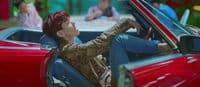 a woman sitting in a red convertible car