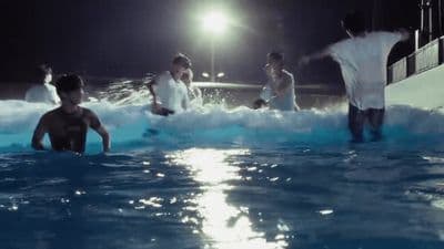 a group of people standing in a pool at night