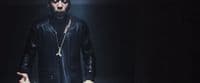 a man in a black leather outfit holding a knife