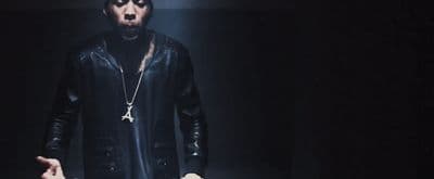 a man in a black leather outfit holding a knife