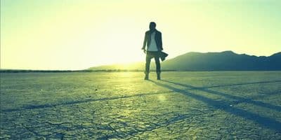 a man standing in the middle of a desert