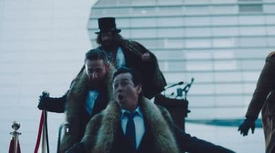 a group of men in suits and ties walking down a street