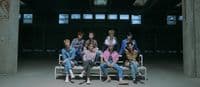 a group of people sitting on top of a white bench