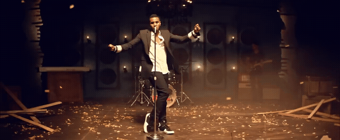 a man standing on top of a stage holding a microphone