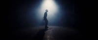 a person standing in a dark room with a light on
