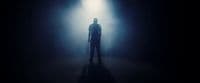 a person standing in a dark room with a light on
