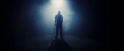 a person standing in a dark room with a light on
