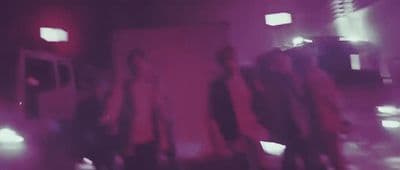 a blurry photo of a group of people walking down a street