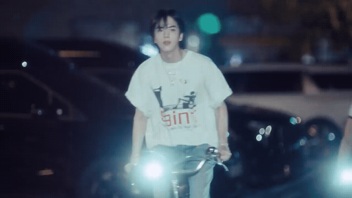 a man riding a bike down a street at night