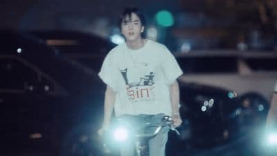 a man riding a bike down a street at night