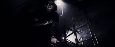 a man standing in a dark room next to a light